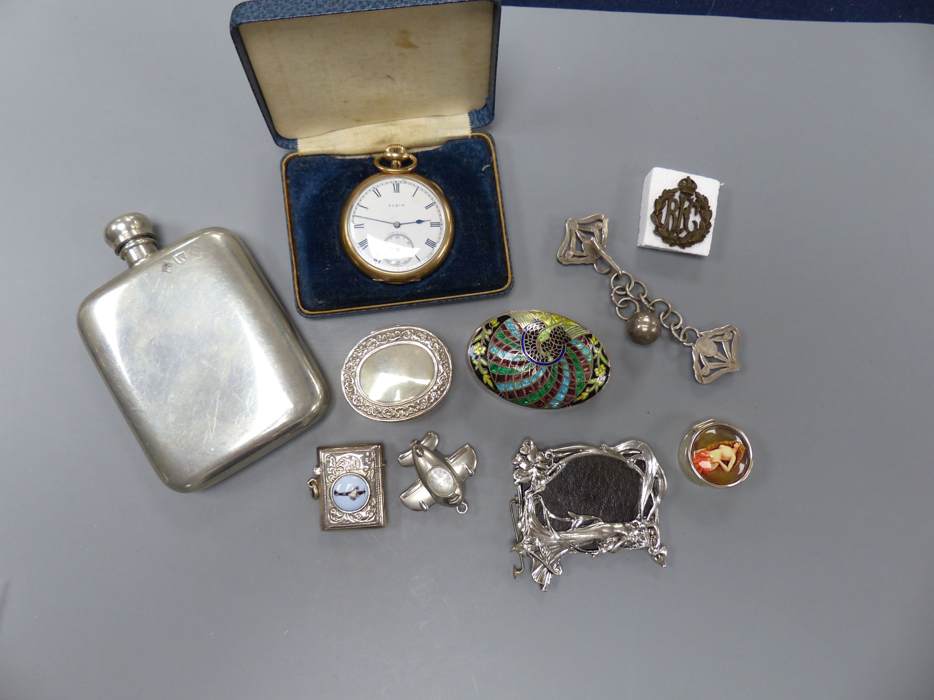 A small group of collectables including gold plated Elgin pocket watch, a 925 and enamel vesta case, three enamelled pill boxes, 'aeroplane' watch pendant, pewter hip flask, photo frame, pair of silver clips and a milita